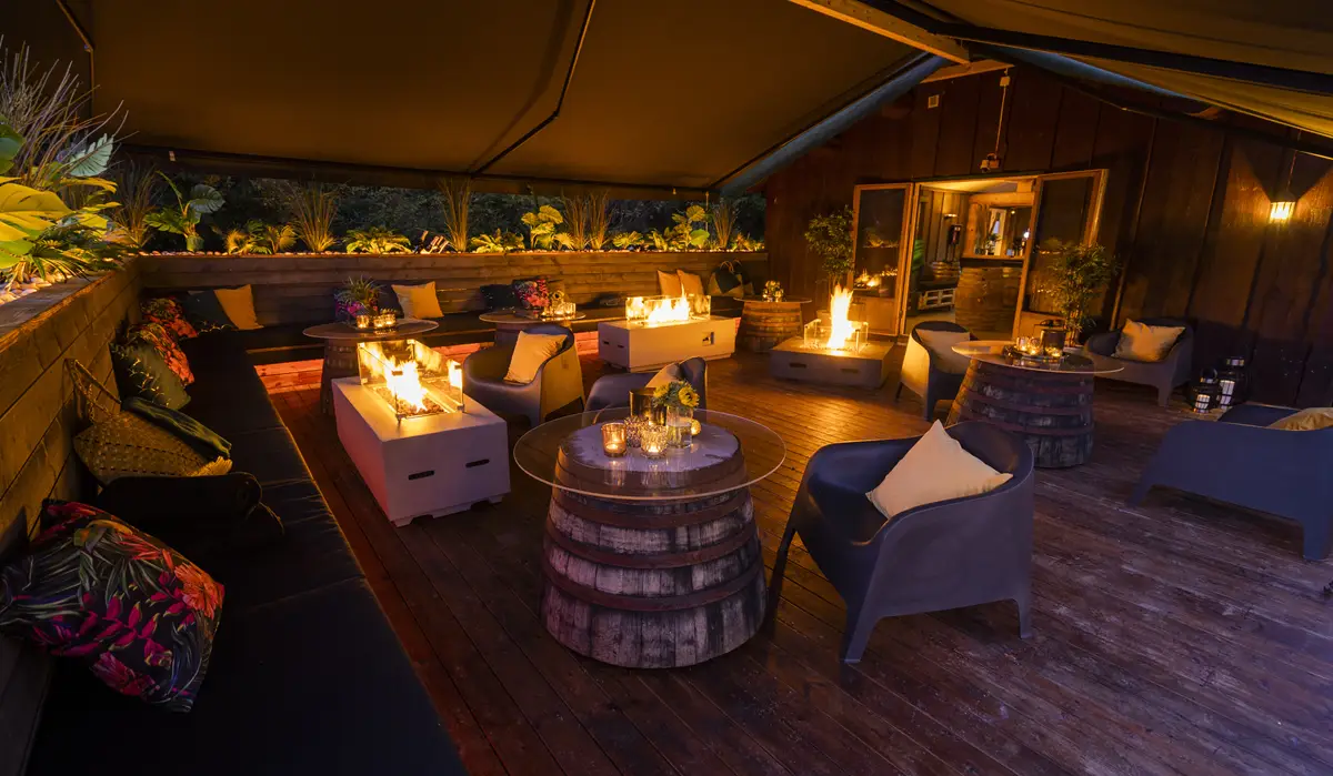 Garden Lounge på Skjetten med sittegrupper, trebord og ildsteder under tak